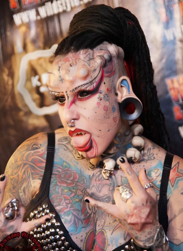 Całe jej ciało pokryte jest tatuażami, ma implanty na twarzy, ponieważ uważa się za wampira: jej wygląd zewnętrzny wcześniej